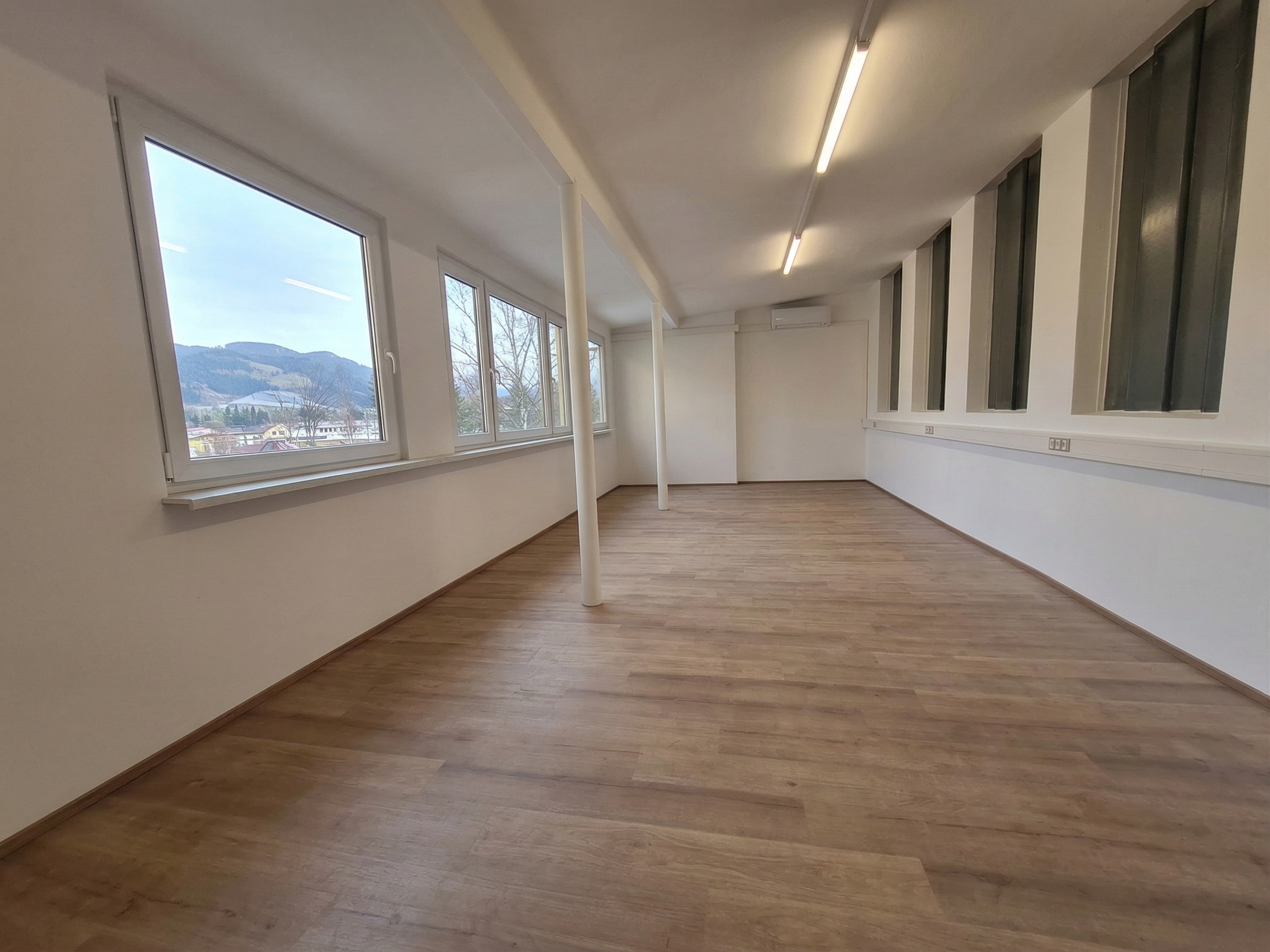 Heller Therapieraum mit Holzboden und Bergblick